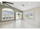 Bright living area with tile flooring, shuttered windows, and views to backyard at 11732 Wheatfield Loop, Hudson, FL 34667