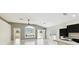 Bright living room featuring tile flooring, a ceiling fan, and multiple windows with plantation shutters at 11732 Wheatfield Loop, Hudson, FL 34667