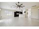 Open living area features a ceiling fan, tile floors and a kitchen with dark cabinets and white countertops at 11732 Wheatfield Loop, Hudson, FL 34667