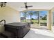 Enclosed patio with ceiling fan, hot tub, and view of golf course at 11732 Wheatfield Loop, Hudson, FL 34667