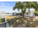 The backyard has a large shade tree, a white fence, and a view of the screened-in porch at 12065 Shadow Ridge Blvd, Hudson, FL 34669