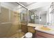 Bathroom features a glass door shower, sink with vanity, toilet, and large mirror at 12065 Shadow Ridge Blvd, Hudson, FL 34669