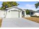 Close-up of an attached garage and landscaped features of the home's exterior at 12065 Shadow Ridge Blvd, Hudson, FL 34669