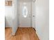 View of a bright hallway with light wood floors and a white door with decorative glass at 12065 Shadow Ridge Blvd, Hudson, FL 34669