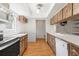 Galley kitchen featuring wood cabinets, modern appliances, and wood flooring at 12065 Shadow Ridge Blvd, Hudson, FL 34669