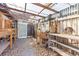 Enclosed outdoor workspace shed with wood tables, shelves, and tools for various projects at 12065 Shadow Ridge Blvd, Hudson, FL 34669