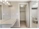 Bathroom with a vanity, tiled floors, and an adjacent walk-in closet at 12204 Pepper Mill Dr, Hudson, FL 34667