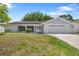 Charming single-story home with a two-car garage, well-maintained lawn, and solar panels on the roof at 12204 Pepper Mill Dr, Hudson, FL 34667