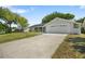 Well-manicured lawn leading to a charming single-story home with an attached two-car garage at 12204 Pepper Mill Dr, Hudson, FL 34667