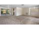 Bright living room with sliding glass doors, neutral carpet, and access to the kitchen at 12204 Pepper Mill Dr, Hudson, FL 34667