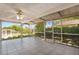 Screened porch with tile flooring and a ceiling fan, offering views of the backyard at 12204 Pepper Mill Dr, Hudson, FL 34667