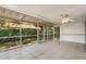 Screened porch with tile flooring, offering a view of the landscaped backyard at 12204 Pepper Mill Dr, Hudson, FL 34667