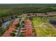 Beautiful aerial view showcases the community homes with red tile roofs nestled among lush fairways and serene ponds at 1260 Dartford Dr, Tarpon Springs, FL 34688