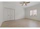 Bright bedroom featuring a closet, ceiling fan, tile floors and a large window for plenty of natural light at 1260 Dartford Dr, Tarpon Springs, FL 34688