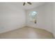 Bright bedroom with a ceiling fan, tiled floors, and a beautiful arched window with plantation shutters at 1260 Dartford Dr, Tarpon Springs, FL 34688