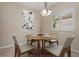 Cozy dining area featuring a round table with chairs set in front of shuttered windows and modern art piece at 1260 Dartford Dr, Tarpon Springs, FL 34688