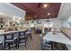Bright dining room features a long bar with granite counters, various tables and chairs, and stylish lighting fixtures at 1260 Dartford Dr, Tarpon Springs, FL 34688