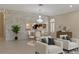 Open-concept living room with a stone accent wall, chandelier, and dining area at 1260 Dartford Dr, Tarpon Springs, FL 34688