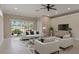 Open living room with tile flooring, comfortable seating, large windows, and an accent wall at 1260 Dartford Dr, Tarpon Springs, FL 34688