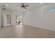 Spacious main bedroom with tile flooring, ceiling fan, lanai access, and neutral decor at 1260 Dartford Dr, Tarpon Springs, FL 34688