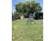 Fenced backyard featuring a large grassy area with a swing set and a shaded gazebo-style structure at 13111 Sheridan Dr, Hudson, FL 34667
