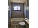 Bathroom showcasing a bathtub and shower with tiled walls, wood-look flooring and a window at 13111 Sheridan Dr, Hudson, FL 34667