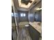 Updated bathroom features wood-look tile floors, grey tiled walls, modern vanity, and updated fixtures at 13111 Sheridan Dr, Hudson, FL 34667