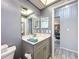 Bathroom with a gray vanity, tile floors, and a mirror providing a clean and stylish space at 13111 Sheridan Dr, Hudson, FL 34667