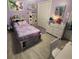 Bedroom with lavender walls, hardwood floors, storage bed and closet with double doors at 13111 Sheridan Dr, Hudson, FL 34667