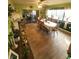Spacious dining room featuring wood-like tile flooring, a long wooden table, and bright green walls at 13111 Sheridan Dr, Hudson, FL 34667
