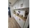 Bright kitchen boasts white subway tile, white cabinets, modern gold hardware and wood countertops at 13111 Sheridan Dr, Hudson, FL 34667