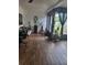 Bright living room with wood-look floors and view to sunroom, blending indoor comfort with a touch of outdoor charm at 13111 Sheridan Dr, Hudson, FL 34667