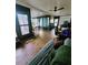 Inviting living room featuring wood-look floors, a ceiling fan, and access to a sunroom for relaxation and natural light at 13111 Sheridan Dr, Hudson, FL 34667