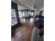 Bright open floor plan between living room and Florida room, featuring wood floors and a ceiling fan at 13111 Sheridan Dr, Hudson, FL 34667