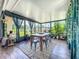 Cozy sunroom with abundant windows, plants, decorative curtains, and a rustic wood table at 13111 Sheridan Dr, Hudson, FL 34667