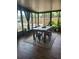 Sunroom with dining table, nice wood-look floors and view to the backyard at 13111 Sheridan Dr, Hudson, FL 34667