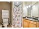 A bathroom featuring a toilet, a vanity with granite countertops, and a shower with a patterned curtain at 1340 Bayshore Blvd # 411, Dunedin, FL 34698