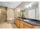 A bathroom featuring a double vanity with granite countertops, a soaking tub, and a glass-enclosed shower at 1340 Bayshore Blvd # 411, Dunedin, FL 34698