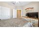 A bright bedroom with a ceiling fan, a flat-screen TV, and an open doorway to another room at 1340 Bayshore Blvd # 411, Dunedin, FL 34698