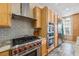 Modern kitchen with a stainless steel range hood, stainless appliances, and tiled backsplash at 1340 Bayshore Blvd # 411, Dunedin, FL 34698