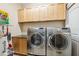 Well-equipped laundry room featuring front-load washer and dryer, ample cabinetry, and granite countertop folding space at 1340 Bayshore Blvd # 411, Dunedin, FL 34698