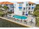 Inviting waterfront condo complex featuring a community pool, hot tub, lounge chairs and tables at 1340 Bayshore Blvd # 411, Dunedin, FL 34698