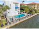Waterfront condo complex offering community pool, lounge chairs, tables and tropical landscaping at 1340 Bayshore Blvd # 411, Dunedin, FL 34698
