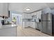 Bright kitchen with white cabinetry, stainless steel appliances, and wood-look tile flooring at 13632 Britton Dr, Hudson, FL 34667