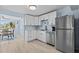 Bright kitchen with white cabinetry, stainless steel appliances, and wood-look tile flooring at 13632 Britton Dr, Hudson, FL 34667