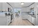 Modern kitchen featuring white cabinets, wood-look flooring, and a view to the adjacent dining area at 13632 Britton Dr, Hudson, FL 34667
