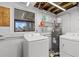Functional laundry room featuring a washer, dryer, and storage shelf for supplies at 13632 Britton Dr, Hudson, FL 34667