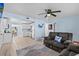 Cozy living room featuring tile floors, ceiling fan, and comfortable gray sofa with a blue accent pillow at 13632 Britton Dr, Hudson, FL 34667