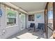 Relaxing screened-in patio with rocking chairs, beachy decor, and a view to the back yard at 13632 Britton Dr, Hudson, FL 34667