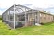 View of the backyard with the screened-in lanai with a pool, BBQ, and grassy lawn at 13942 Talmage Loop, Hudson, FL 34667